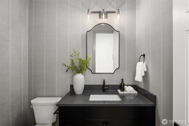 a bathroom with a toilet sink and mirror