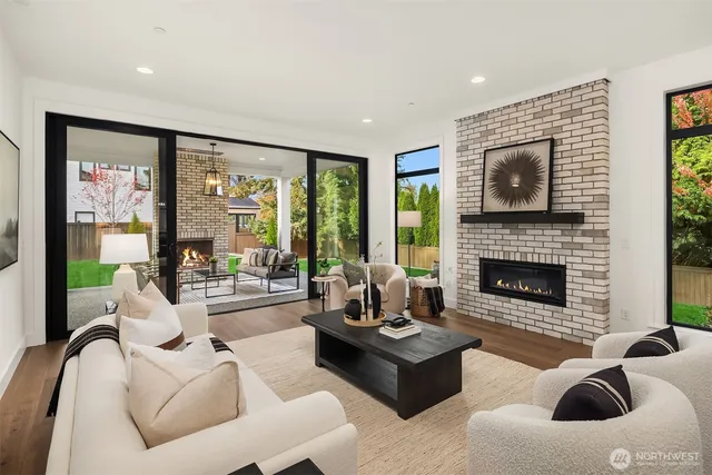 a living room with furniture fireplace and floor to ceiling windows