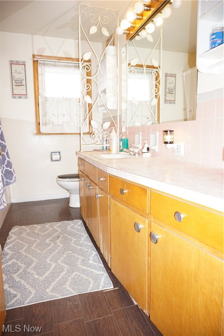4611 8th Street Northwest Canton, OH 44708 - Photo 15 of 29 Bathroom with toilet, backsplash, and vanity