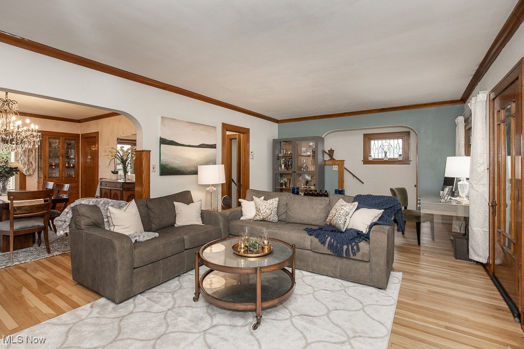 7070 Ridge Road Parma, OH 44129 - Photo 2 of 28 Living room with an inviting chandelier, crown molding, and hardwood / wood-style floors