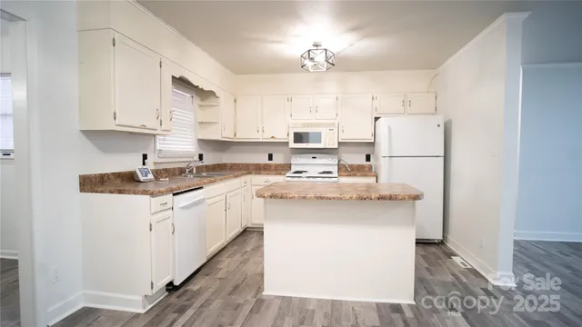a kitchen with kitchen island white cabinets and white appliances