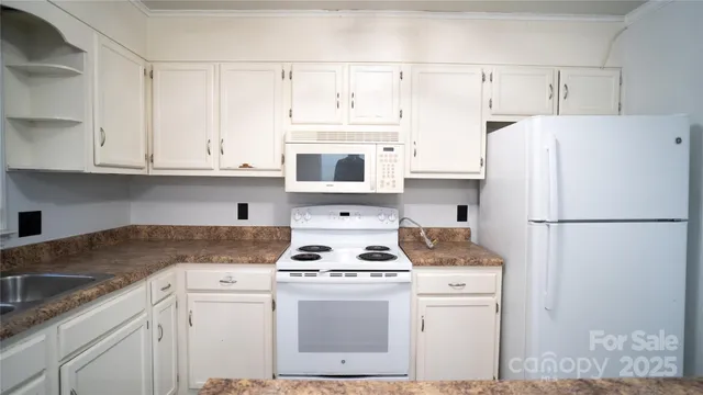 a kitchen with white cabinets and white appliances
