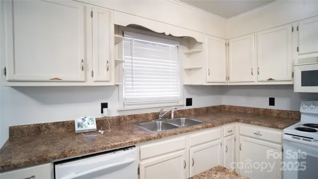 a kitchen with granite countertop white cabinets and a sink