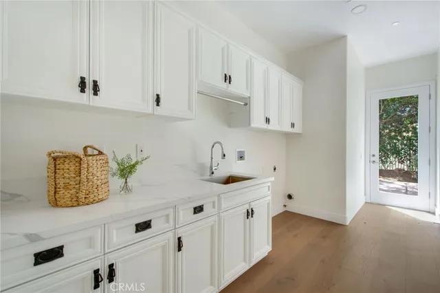 a kitchen with white cabinets a sink and dishwasher