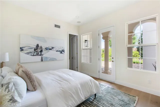 a bedroom with a large bed and a wooden floor