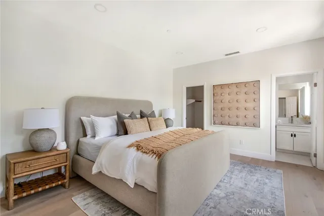 a bedroom with a bed and painting on the wall