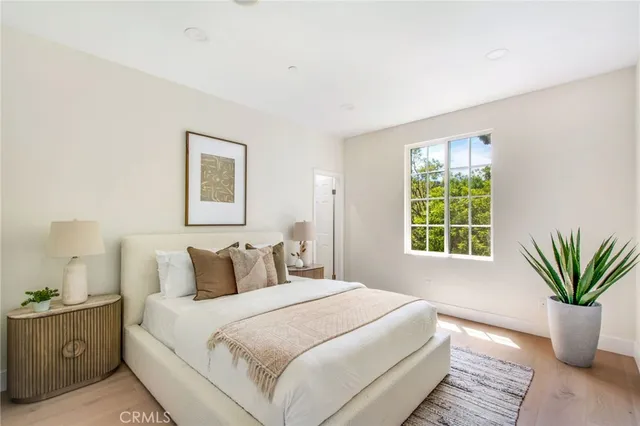 a bedroom with a large bed and a potted plant