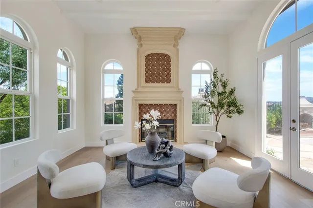 a living room with furniture a fireplace and potted plants