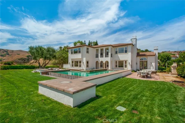 an aerial view of a house with a yard and large tree
