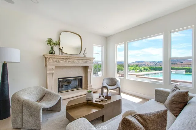 a living room with furniture a fireplace and a large window