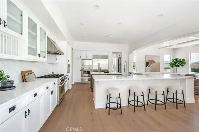 a kitchen with white cabinets and chairs