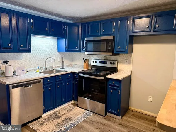 a kitchen with stainless steel appliances granite countertop wooden cabinets a stove top oven a sink and dishwasher