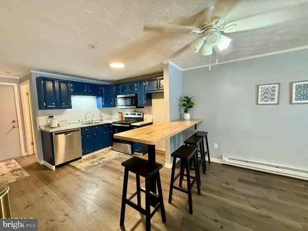a kitchen with a table chairs refrigerator and microwave