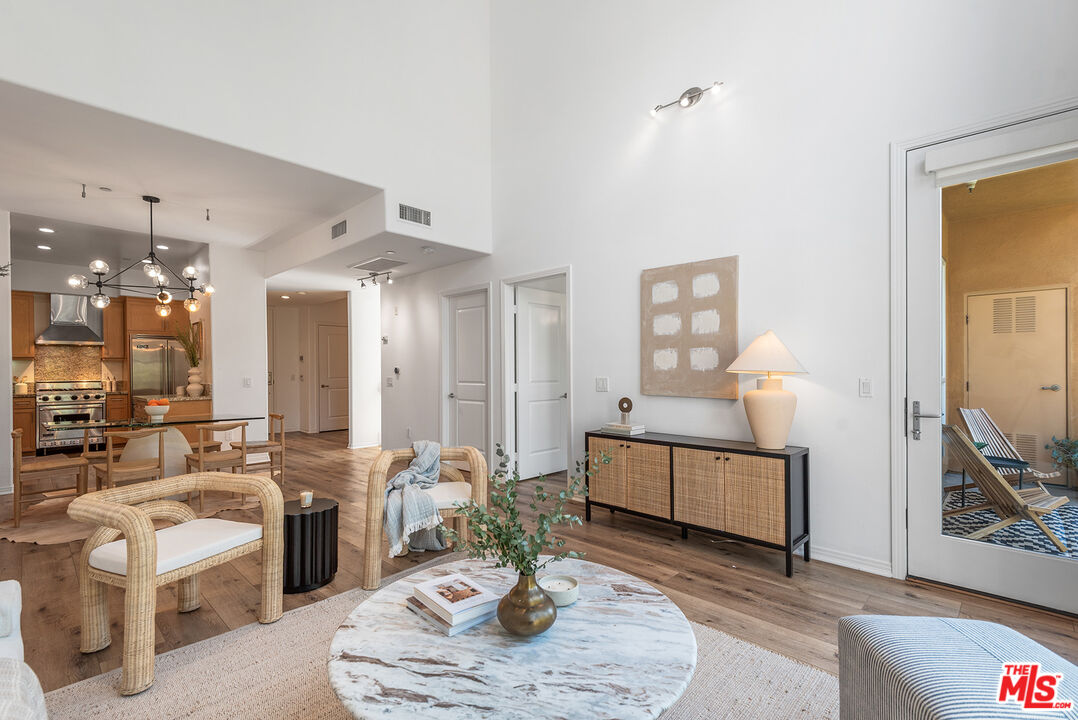 4050 Glencoe Avenue, Unit 414 Marina del Rey, CA 90292 - Photo 2 of 31 a living room with furniture potted plant and a chandelier