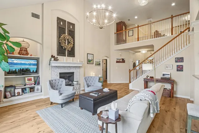 a kitchen with stainless steel appliances granite countertop wooden cabinets a sink dishwasher a stove and a refrigerator with wooden floor