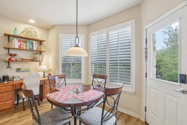 a dining room with furniture a chandelier and wooden floor