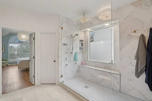 a bedroom with furniture and a large window