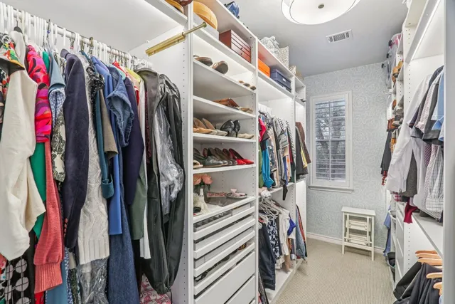 a bedroom with a bed a desk and chair with wooden floor