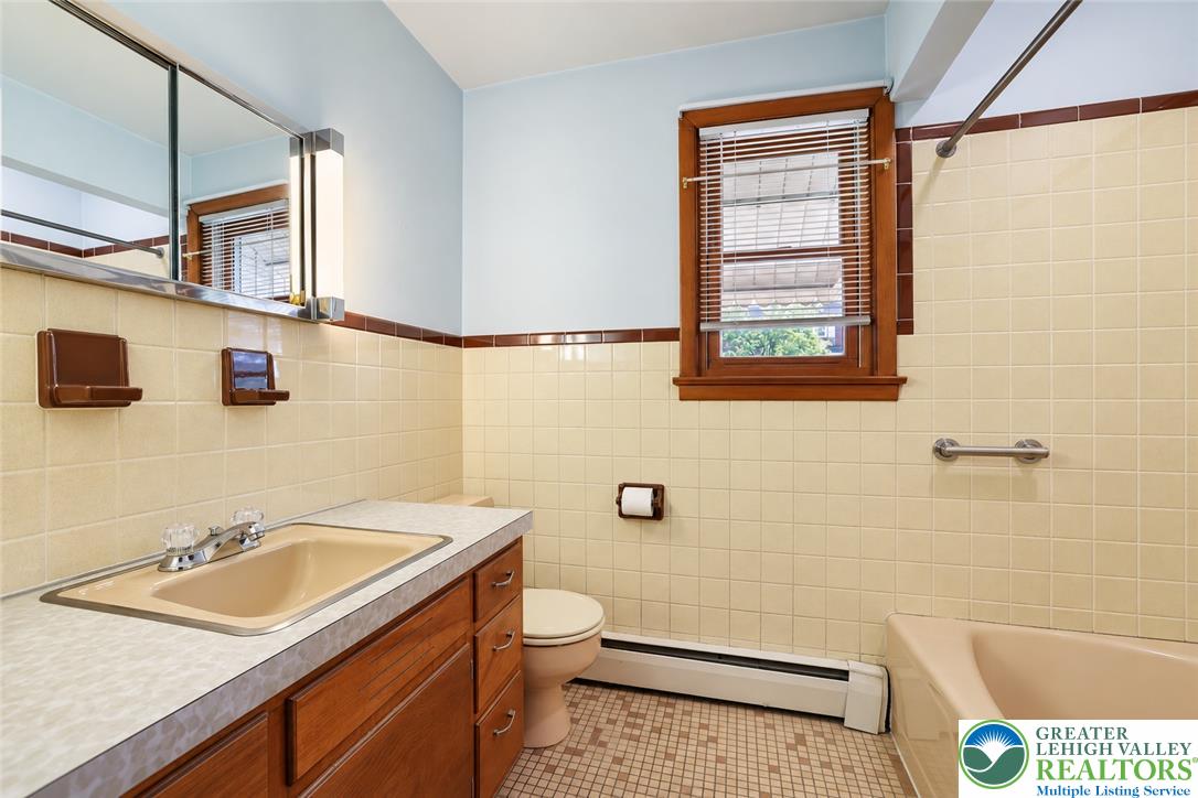 1539 Spring Garden Street Wilson, PA 18042 - Photo 21 of 34 Classic mid-century wall tiles and a wood vanity define this traditional full bathroom.