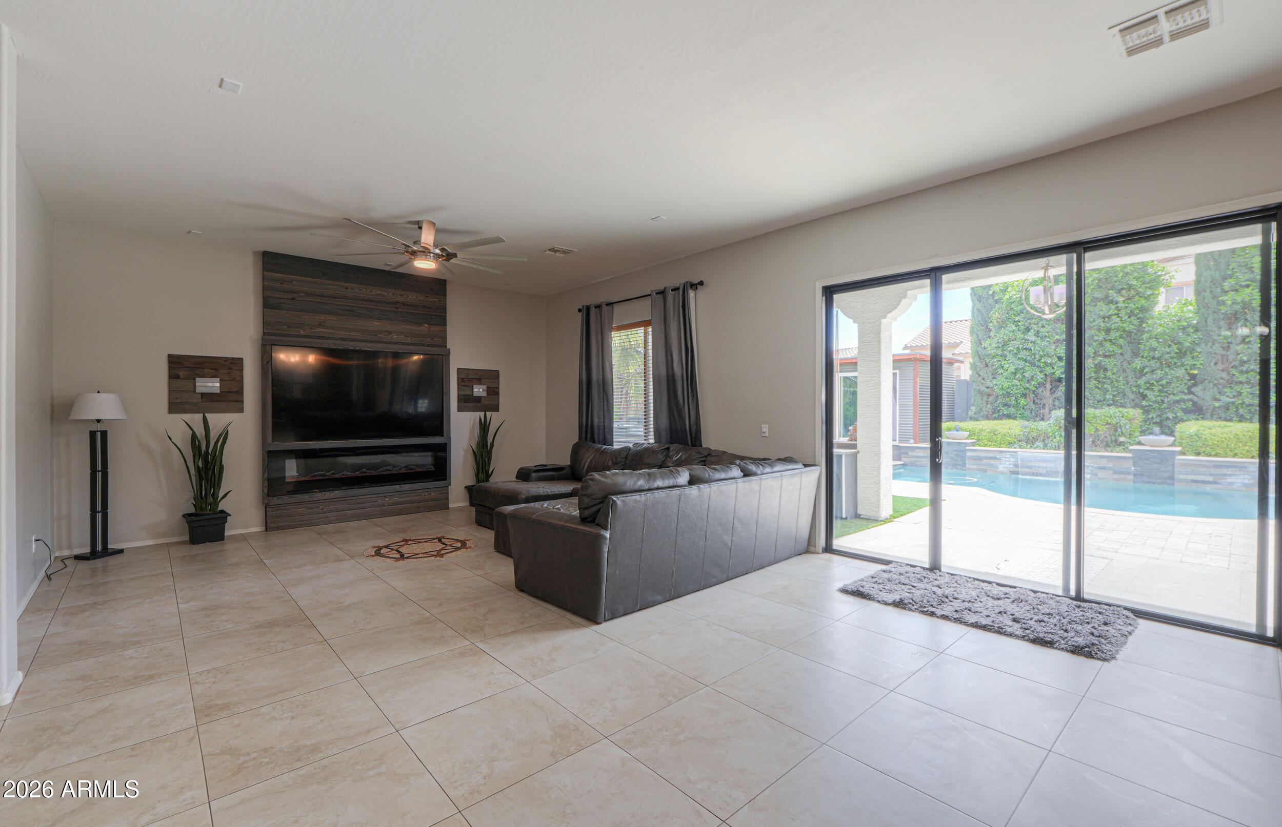 45247 West Jack Rabbit Trail Maricopa, AZ 85139 - Photo 23 of 75 a living room with furniture a flat screen tv and floor to ceiling window