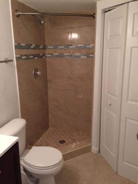 8183 Thames Boulevard, Unit B Boca Raton, FL 33433 - Photo 6 of 12 a bathroom with a granite countertop toilet a sink and shower