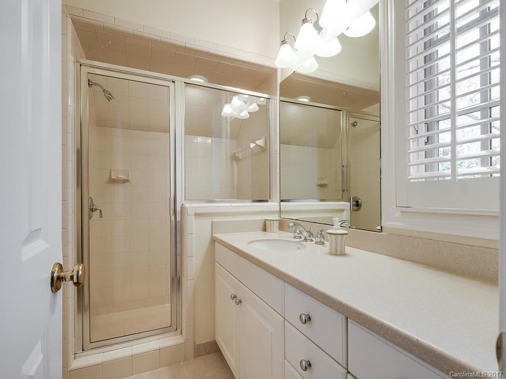 1911 Harris Road Charlotte, NC 28211 - Photo 15 of 24 a bathroom with a shower sink vanity and mirror