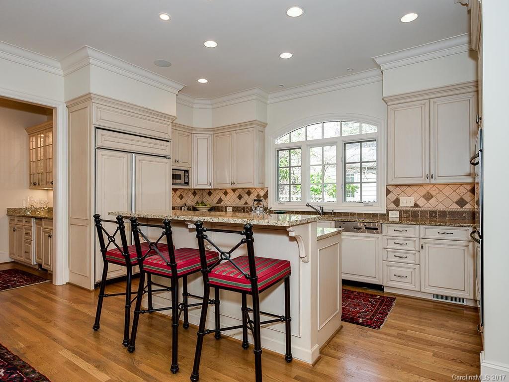 1911 Harris Road Charlotte, NC 28211 - Photo 6 of 24 a kitchen with stainless steel appliances granite countertop a table chairs sink refrigerator and cabinets