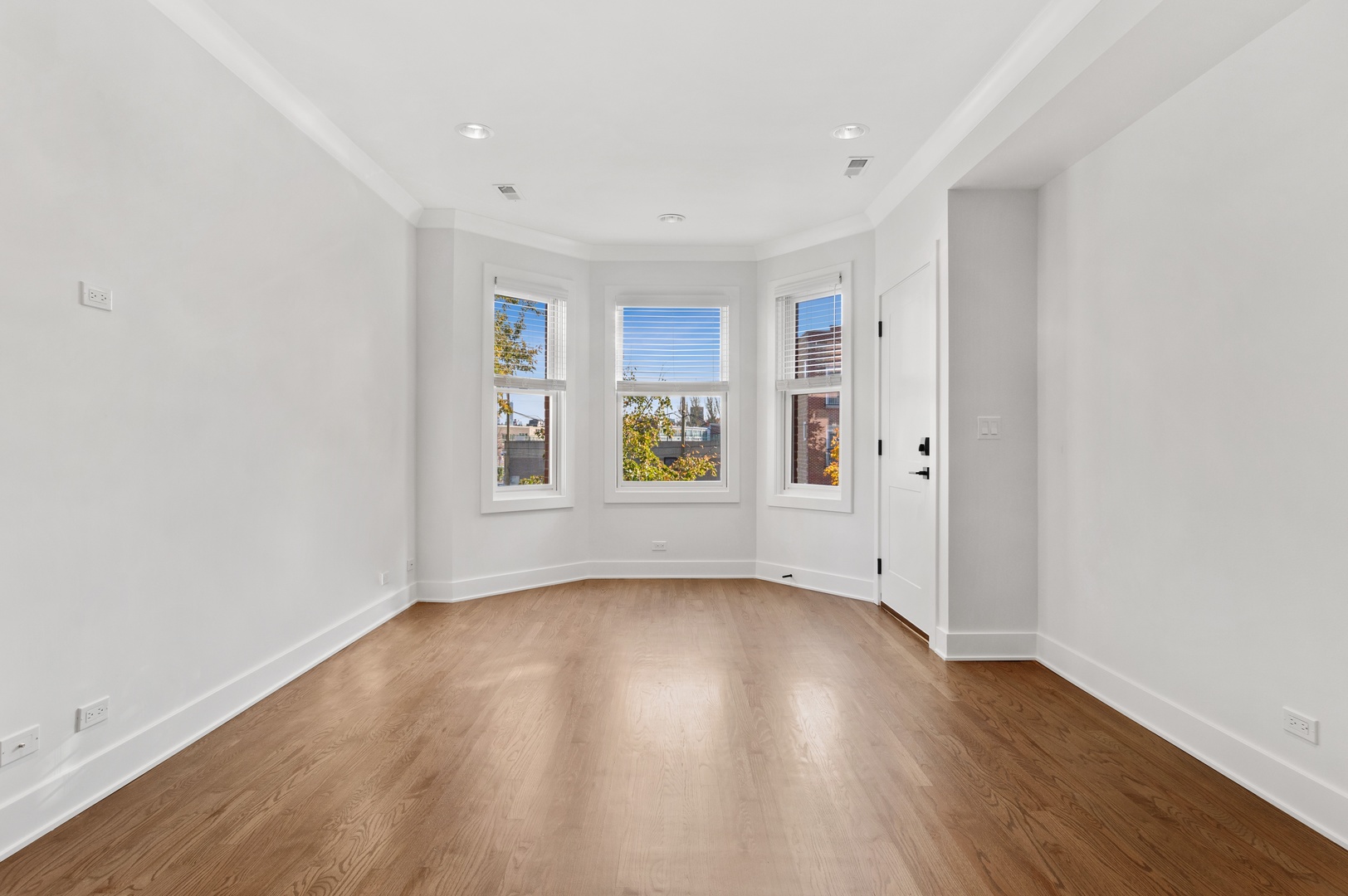 1116 West Addison Street, Unit 2 Chicago, IL 60613 - Photo 2 of 16 an empty room with wooden floor and windows