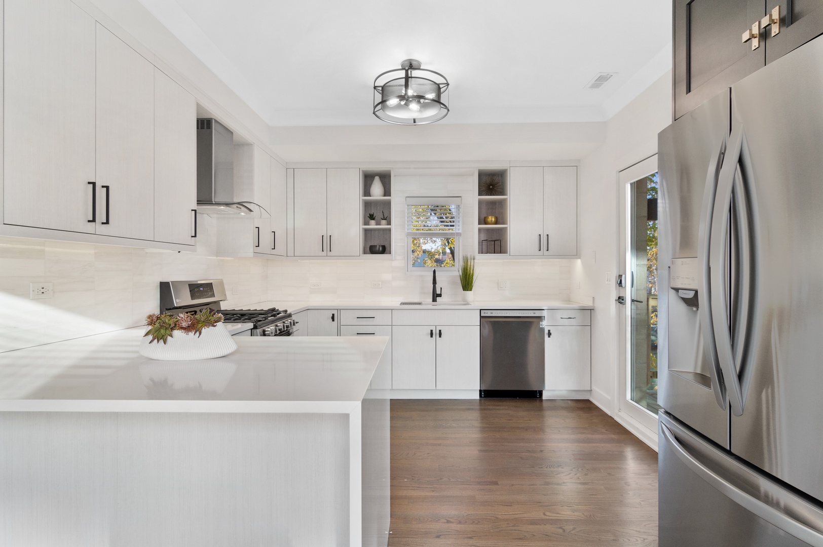 1116 West Addison Street, Unit 2 Chicago, IL 60613 - Photo 8 of 16 a kitchen with a sink a refrigerator a stove and white cabinets