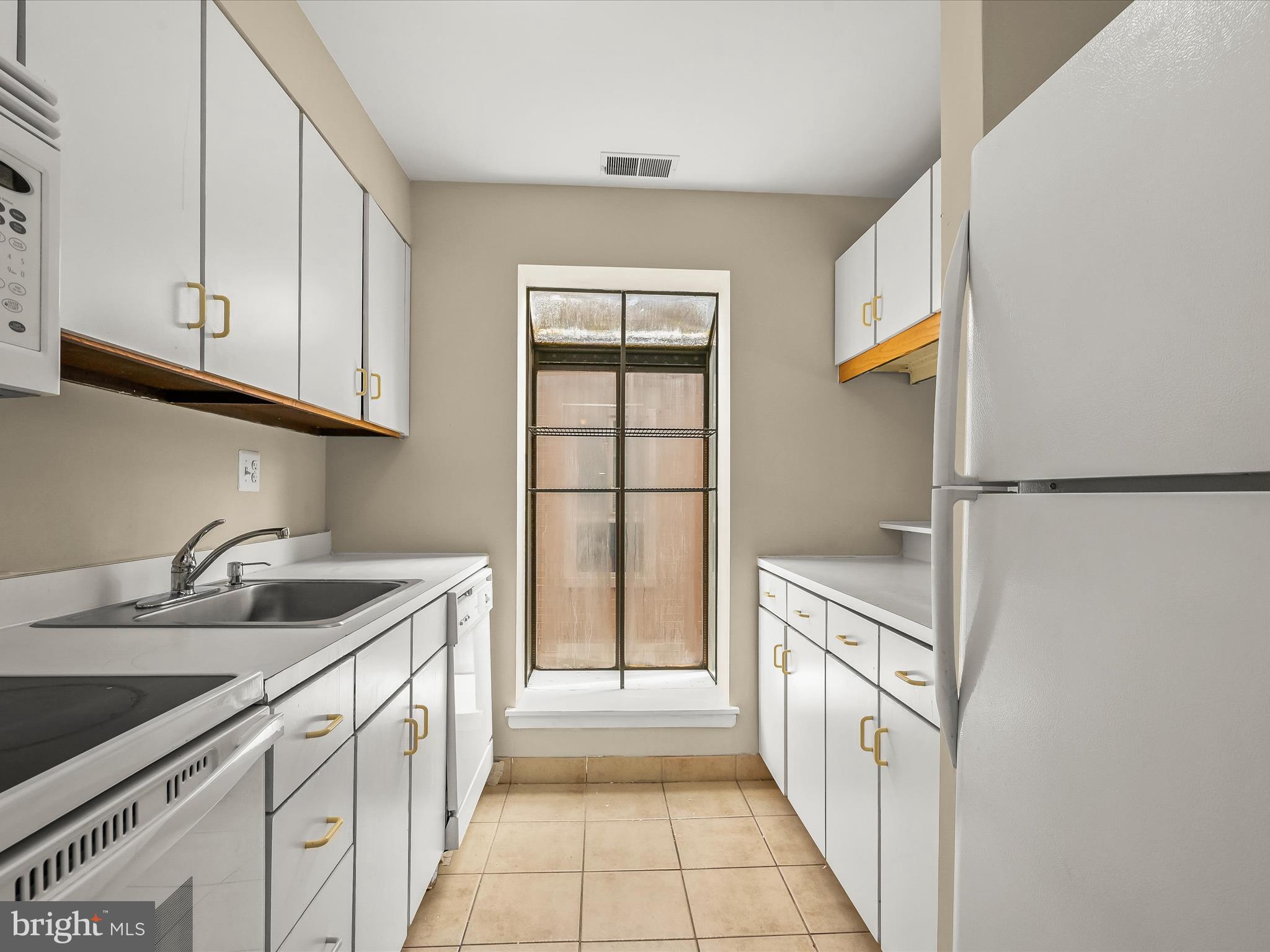 407 South Sharp Street, Unit R 6 Baltimore, MD 21201 - Photo 9 of 20 a kitchen with granite countertop a sink and a refrigerator