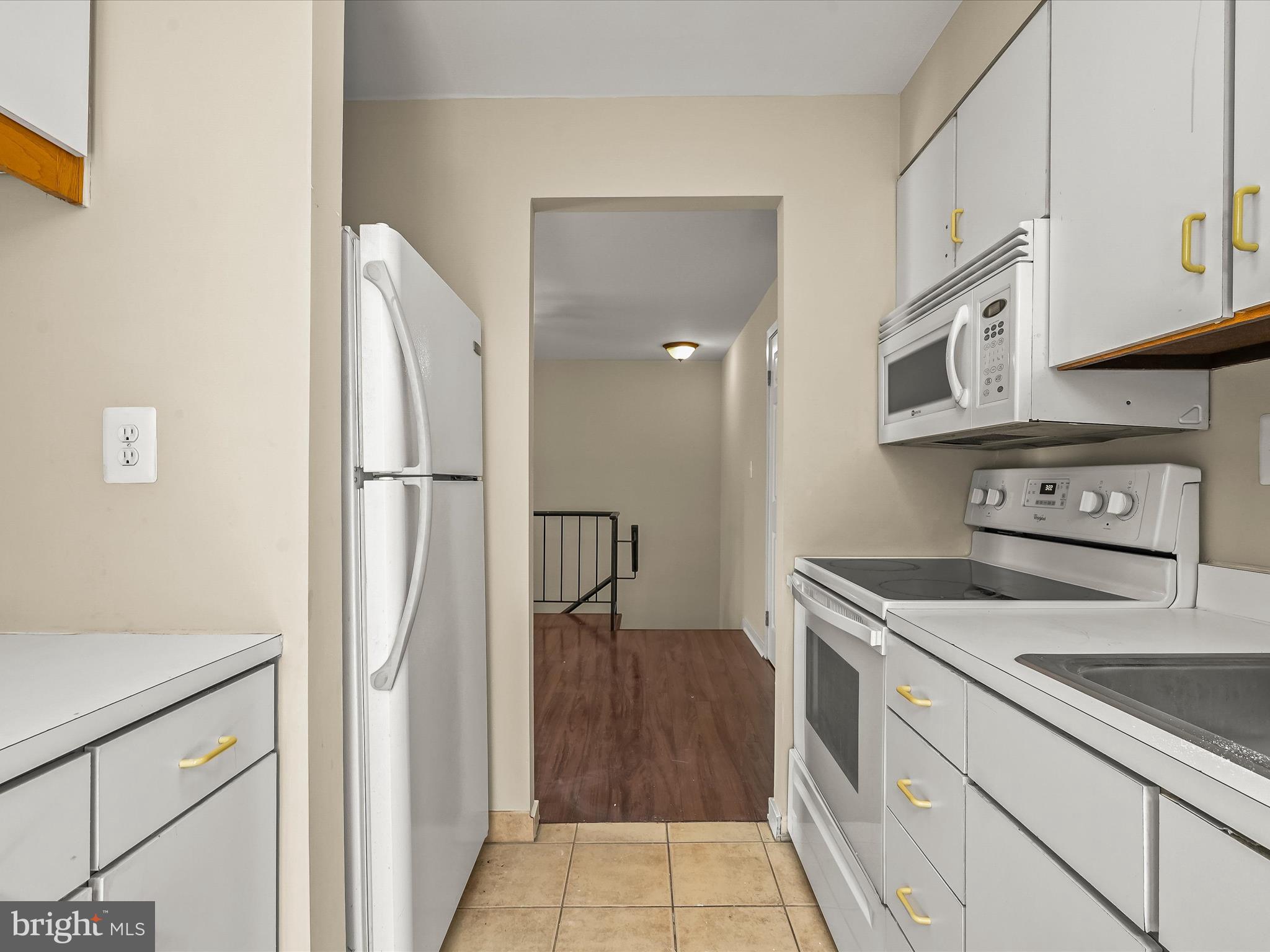 407 South Sharp Street, Unit R 6 Baltimore, MD 21201 - Photo 10 of 20 a kitchen with stainless steel appliances granite countertop a refrigerator a stove and a sink with wooden cabinets
