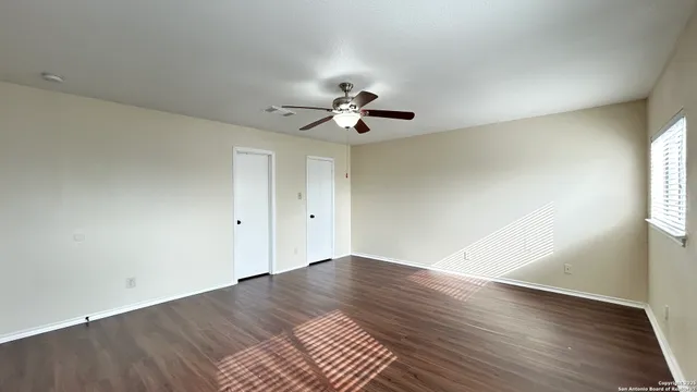 a view of a room with wooden floor and ceiling fan
