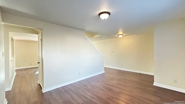 a view of a big room with wooden floor and a ceiling fan