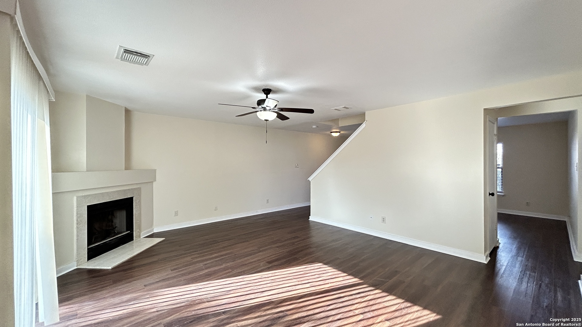 8018 Chestnut Gate Lane Converse, TX 78109 - Photo 7 of 38 a view of an empty room with wooden floor and a fireplace