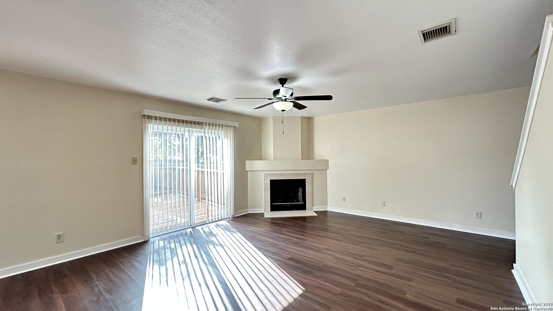 8018 Chestnut Gate Lane Converse, TX 78109 - Photo 8 of 38 an empty room with wooden floor fireplace and windows