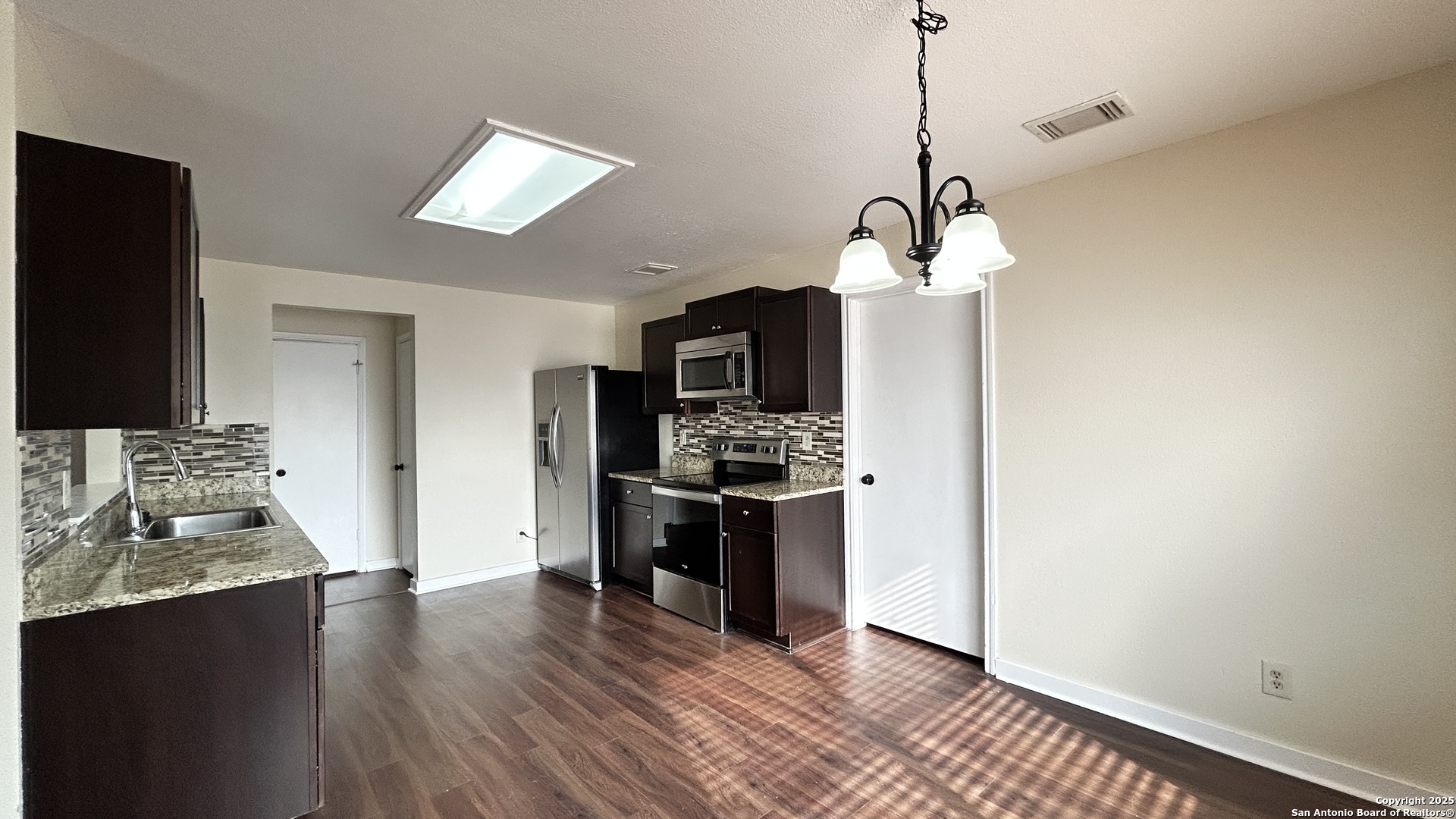8018 Chestnut Gate Lane Converse, TX 78109 - Photo 10 of 38 a kitchen with stainless steel appliances granite countertop a stove a sink dishwasher and a refrigerator with wooden floor