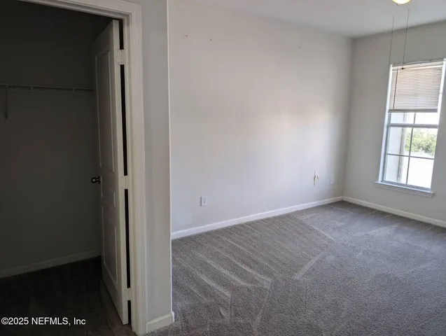 an empty room with windows and closet