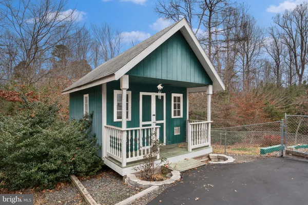 an empty room with wooden floor cabinet and windows