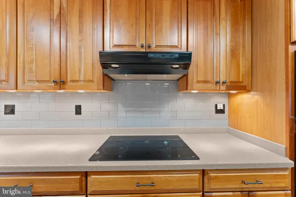 a kitchen with stainless steel appliances kitchen island granite countertop a sink and wooden cabinets