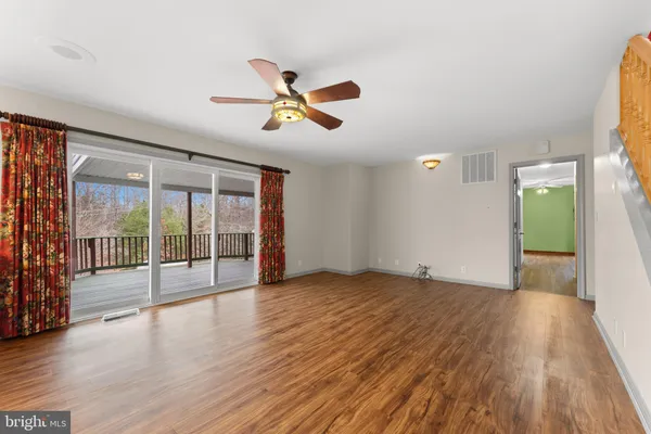 a kitchen with stainless steel appliances granite countertop a refrigerator a sink dishwasher a stove and a dining table with wooden floor