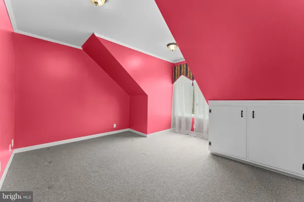 a view of a white house next to a yard with large tree