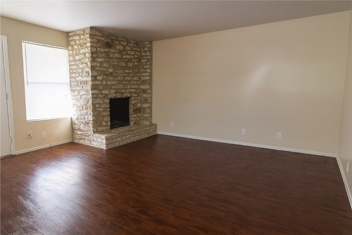 903 Taulbee Lane, Unit D Austin, TX 78757 - Photo 3 of 13 an empty room with wooden floor fire place and windows