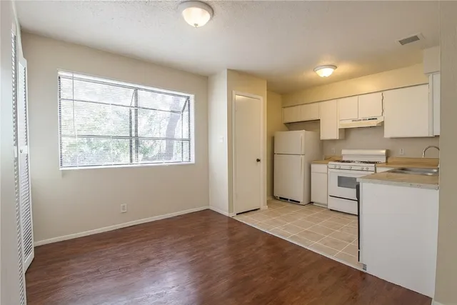 a kitchen with a refrigerator and a stove top oven