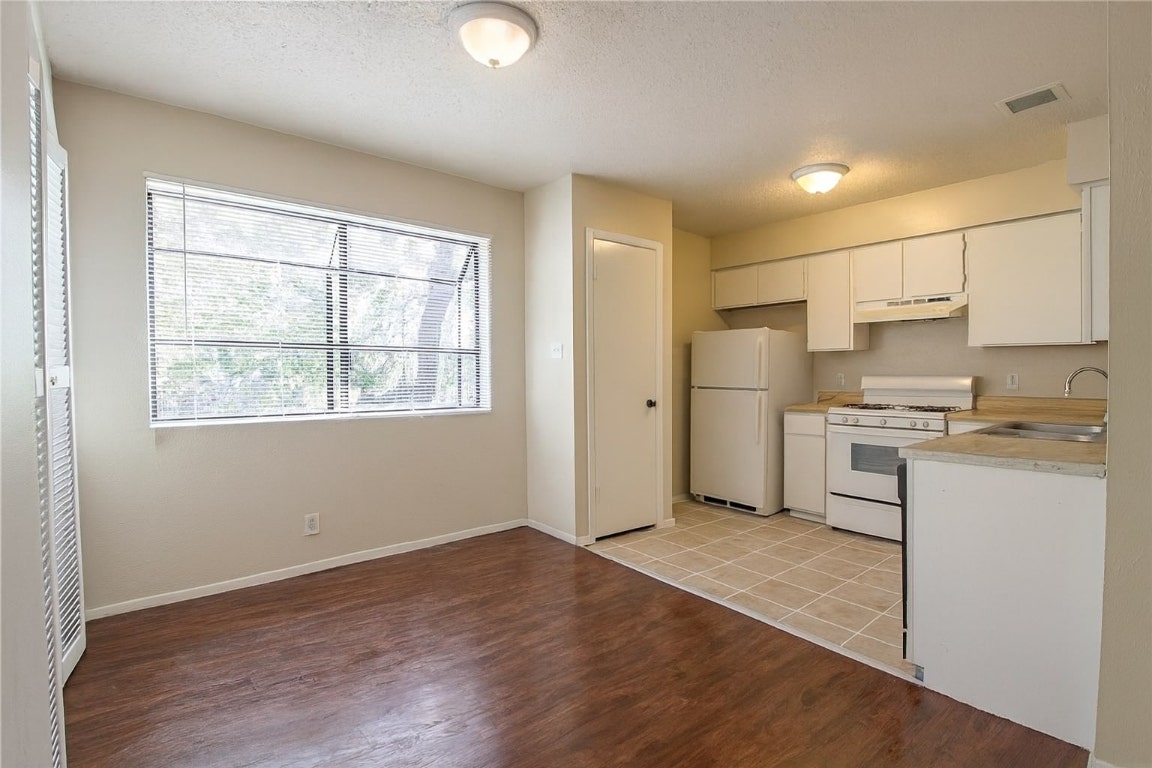 903 Taulbee Lane, Unit D Austin, TX 78757 - Photo 4 of 13 a kitchen with a refrigerator and a stove top oven