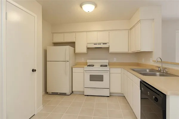a kitchen with a white stove refrigerator and cabinets