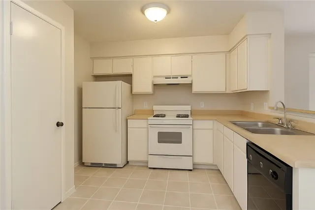a kitchen with a white stove refrigerator and cabinets