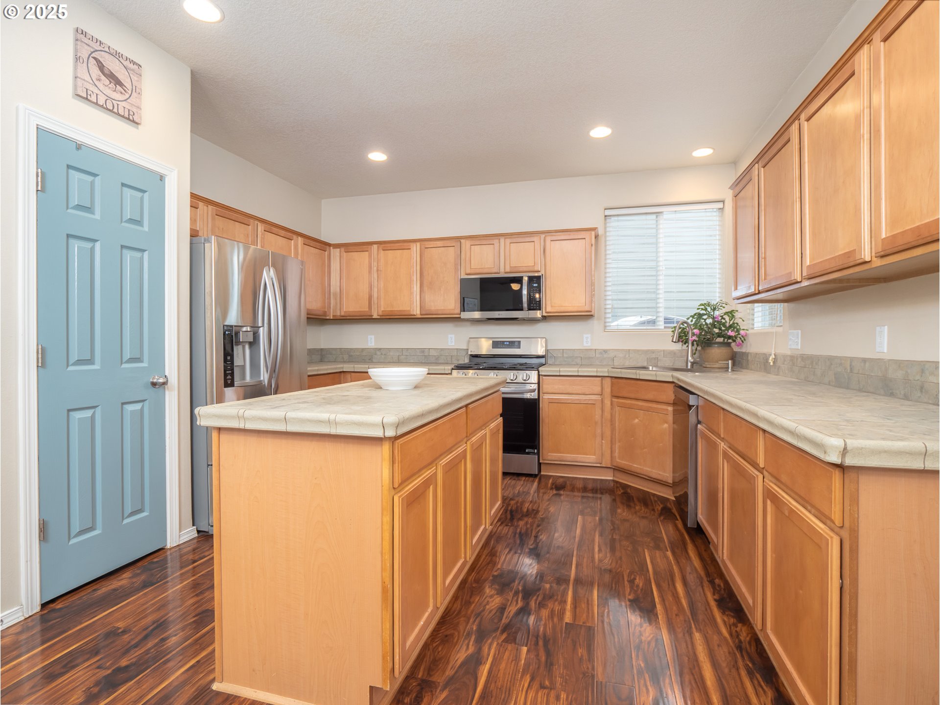121 Burl Street Newberg, OR 97132 - Photo 11 of 48 a kitchen with stainless steel appliances granite countertop a stove top oven a sink dishwasher and a refrigerator with wooden floor