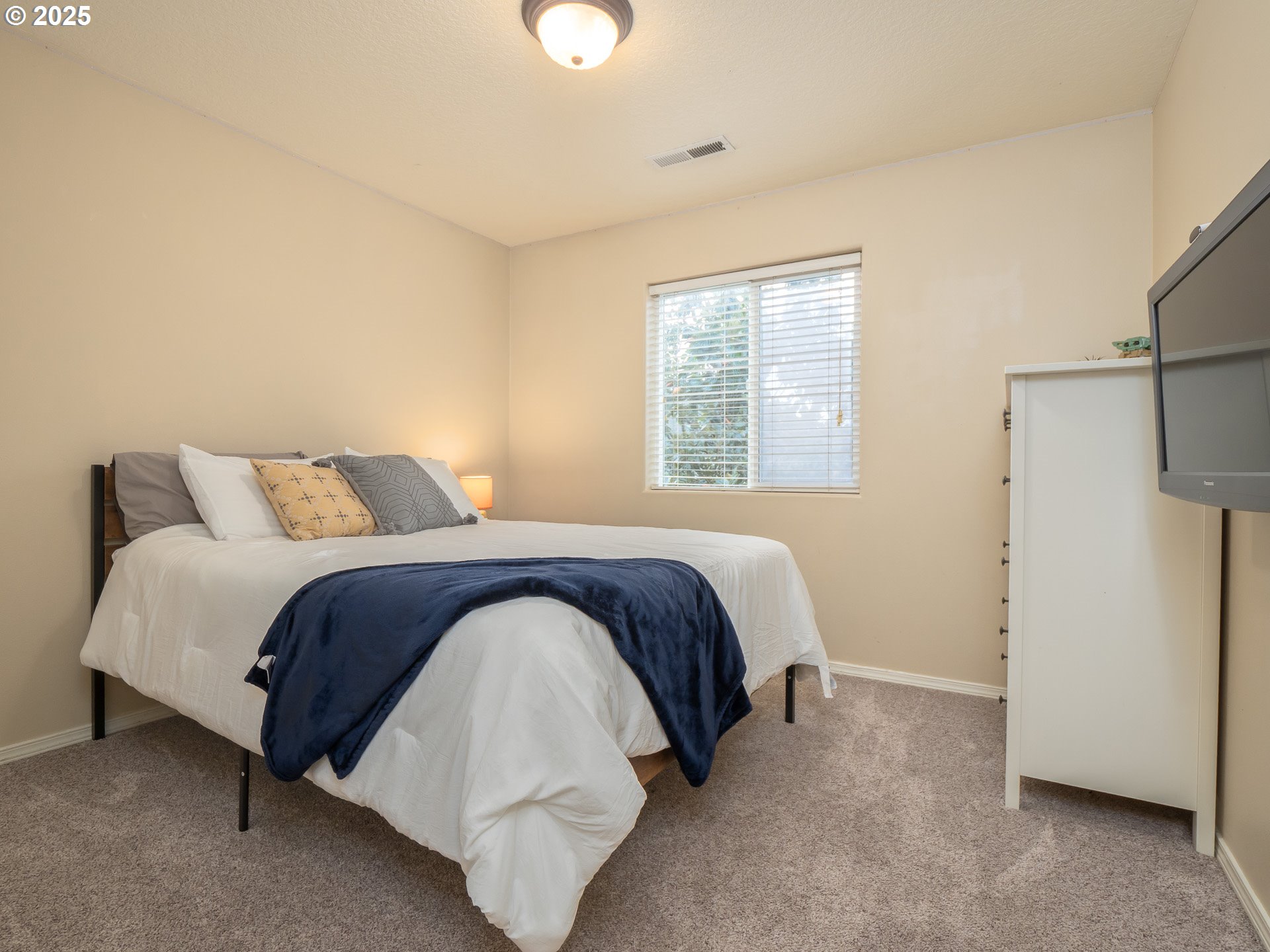 121 Burl Street Newberg, OR 97132 - Photo 27 of 48 a bedroom with a bed and a refrigerator