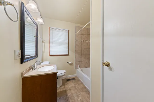 a bathroom with a sink and mirror with toilet