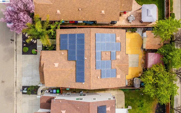 an aerial view of a house with a yard and a large tree